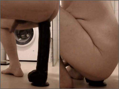 Male rides on the Epic black dildo fully in the bathroom